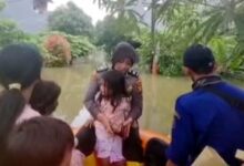 Anggota Polwan Evakuasi Tiga Balita Terjebak Banjir di Kecamatan Periuk