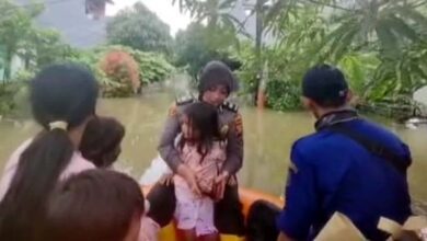 Anggota Polwan Evakuasi Tiga Balita Terjebak Banjir di Kecamatan Periuk