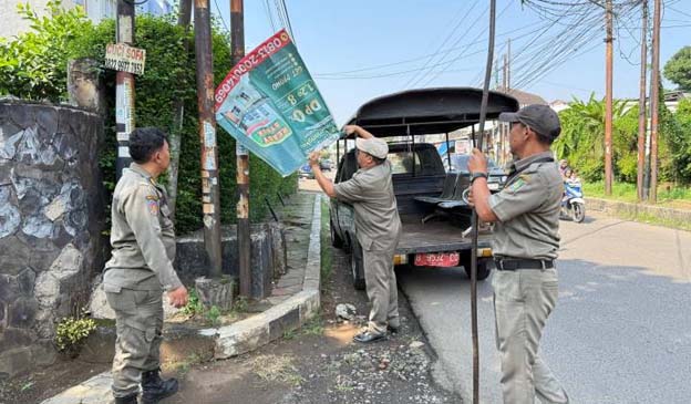 Anggota Trantib Kecamatan Larangan Tertibkan Puluhan Spanduk Liar